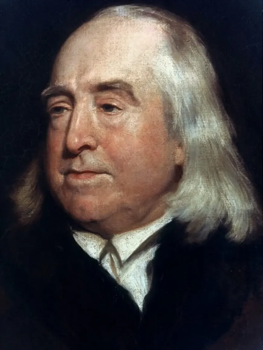 功利主義の創始者、ジェレミー・ベンサムの肖像画。白い髪で、穏やかながらも鋭い眼差しをした晩年の姿。